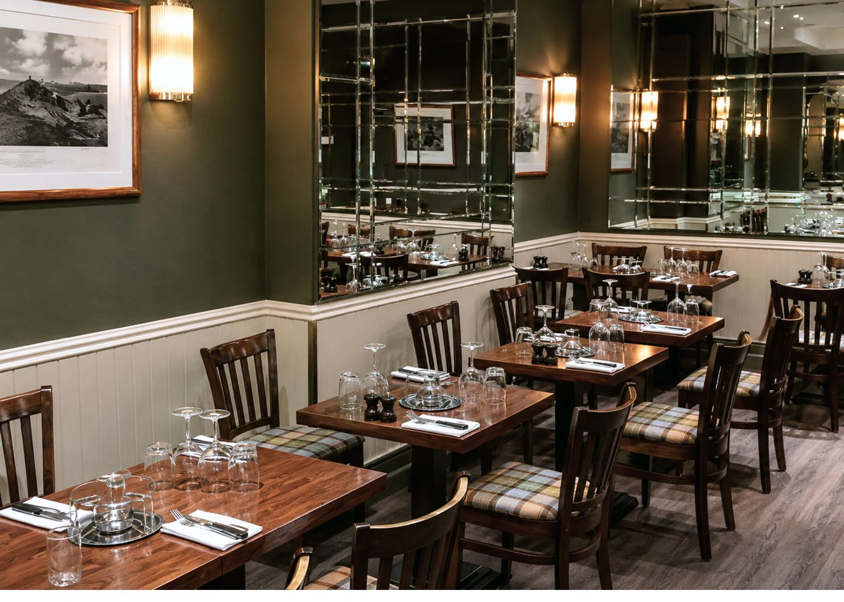 Rowley’s: A dining area with wall lighting and mirrored panels.